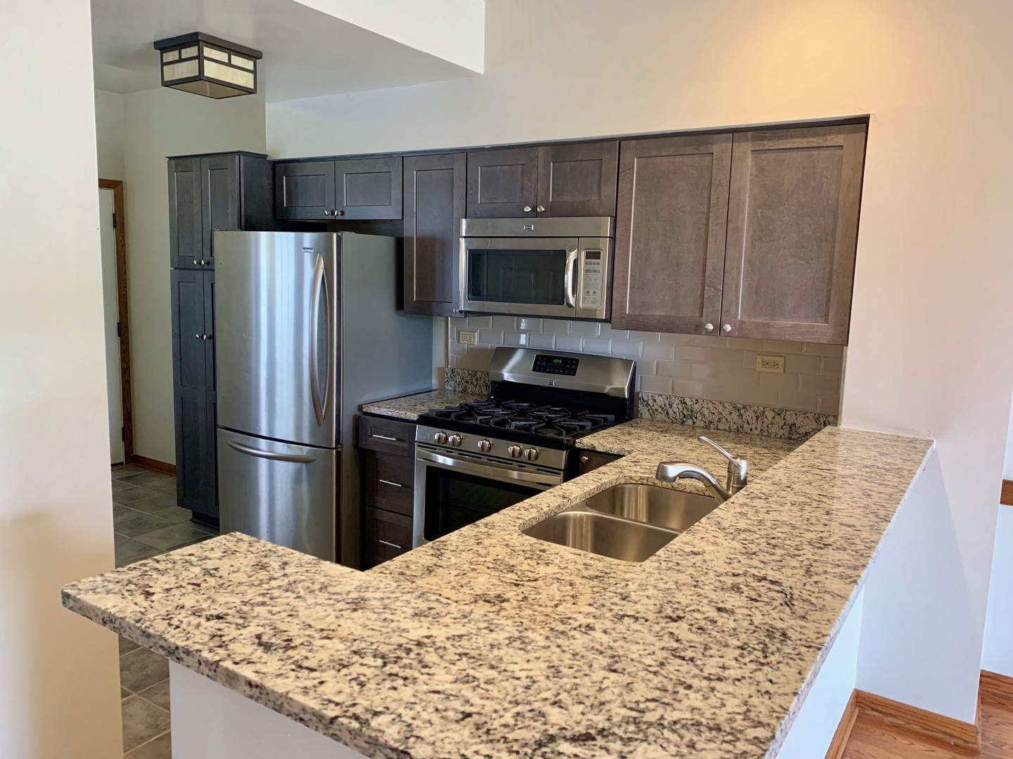 955 Ripple Ridge Cove, Unit 955 Darien, IL 60561 - Photo 3 of 13 a kitchen with granite countertop a refrigerator and a sink