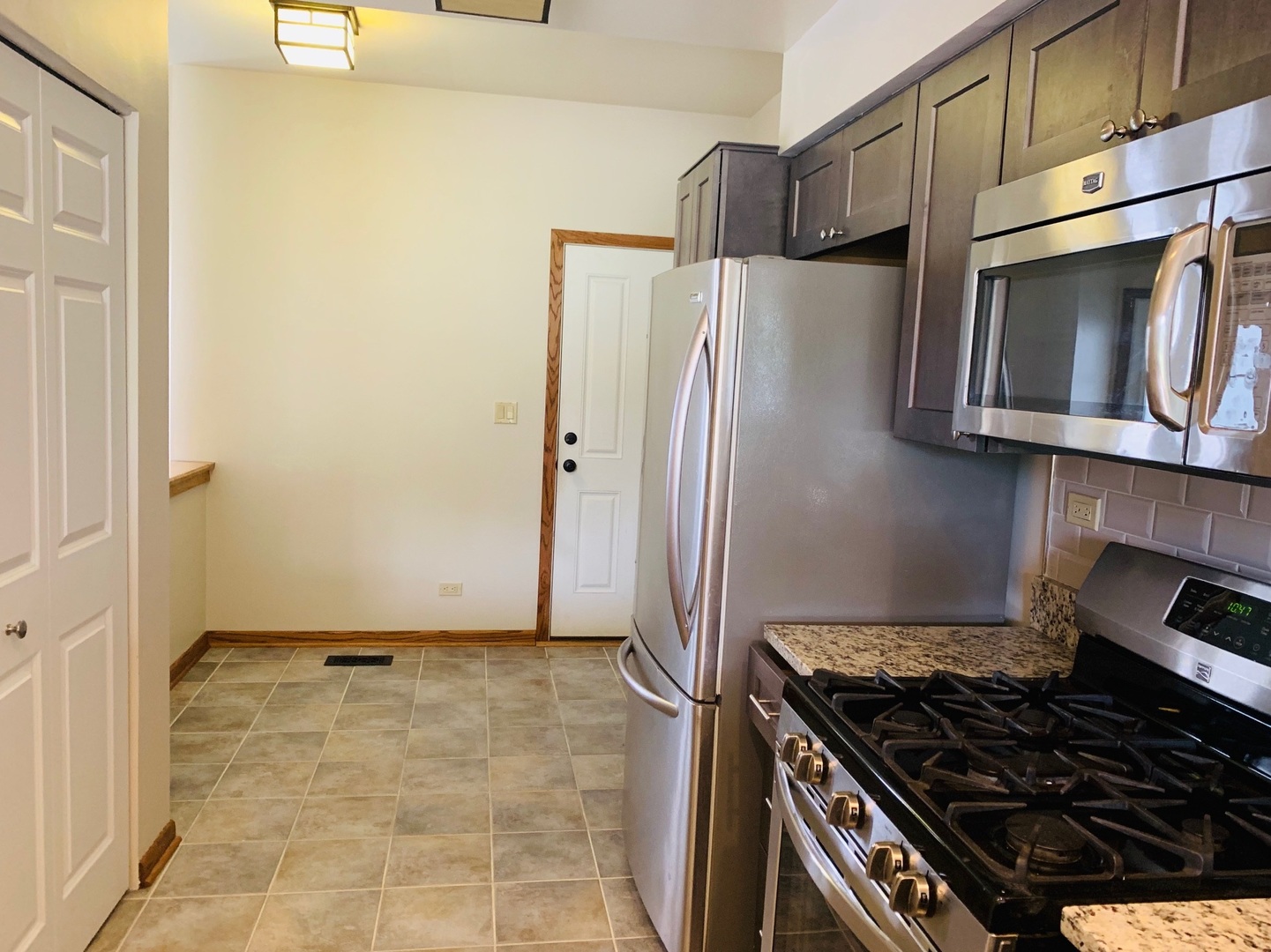 955 Ripple Ridge Cove, Unit 955 Darien, IL 60561 - Photo 4 of 13 a kitchen with stainless steel appliances granite countertop a refrigerator and a stove top oven