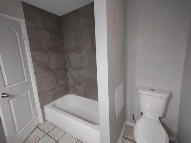 a white toilet sitting next to a bath tub