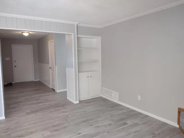 a view of an empty room with wooden floor