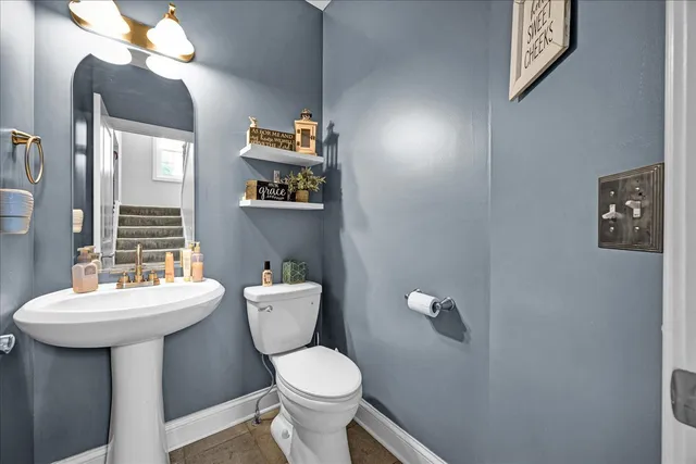 a bathroom with a toilet a sink and mirror