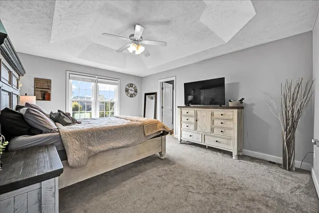 a spacious bedroom with a bed and a flat screen tv