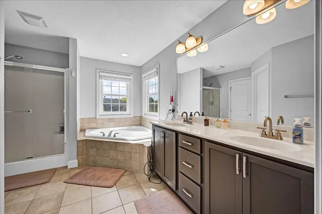 a spacious bathroom with a bathtub a sink and a mirror