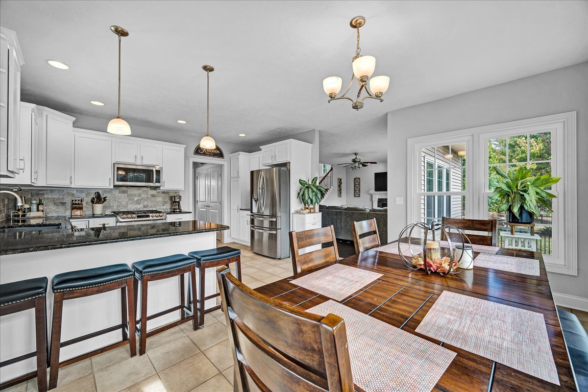 1001 Mugho Court Normal, IL 61761 - Photo 2 of 46 a kitchen with stainless steel appliances granite countertop a stove a sink a dining table and chairs with wooden floor