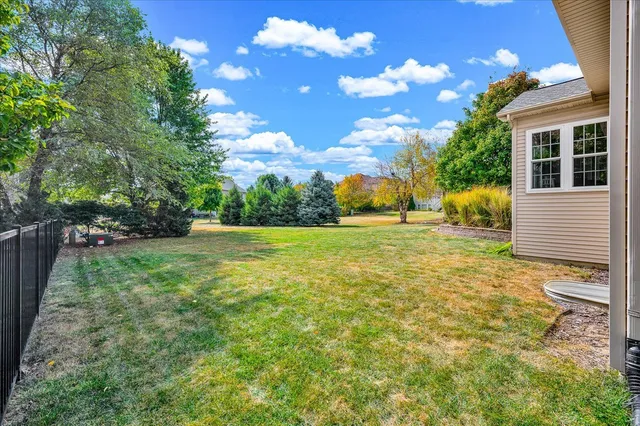 a view of a house with a big yard plants and large trees