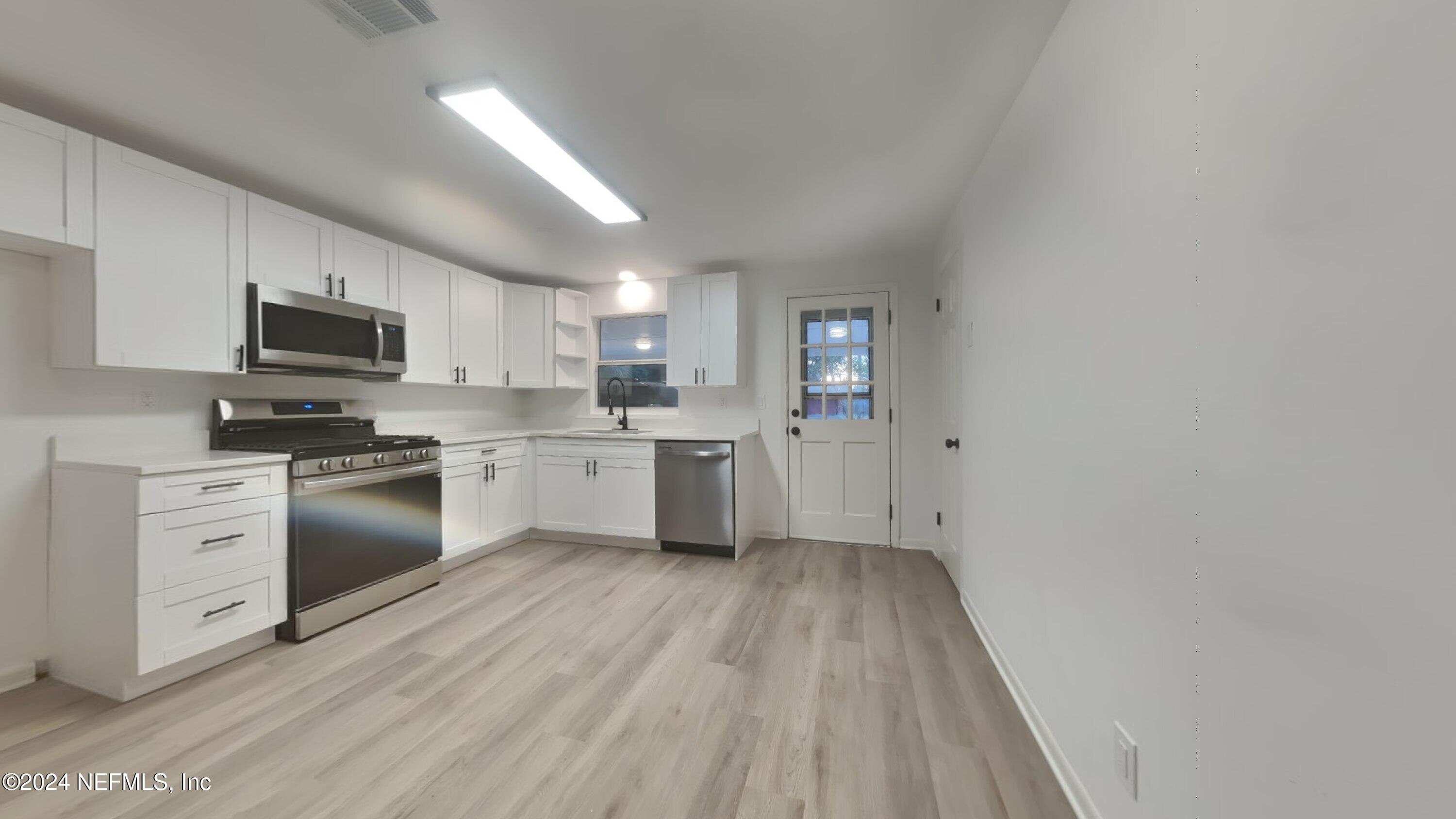 10941 Player Road Jacksonville, FL 32218 - Photo 7 of 15 a kitchen with granite countertop white cabinets and stainless steel appliances