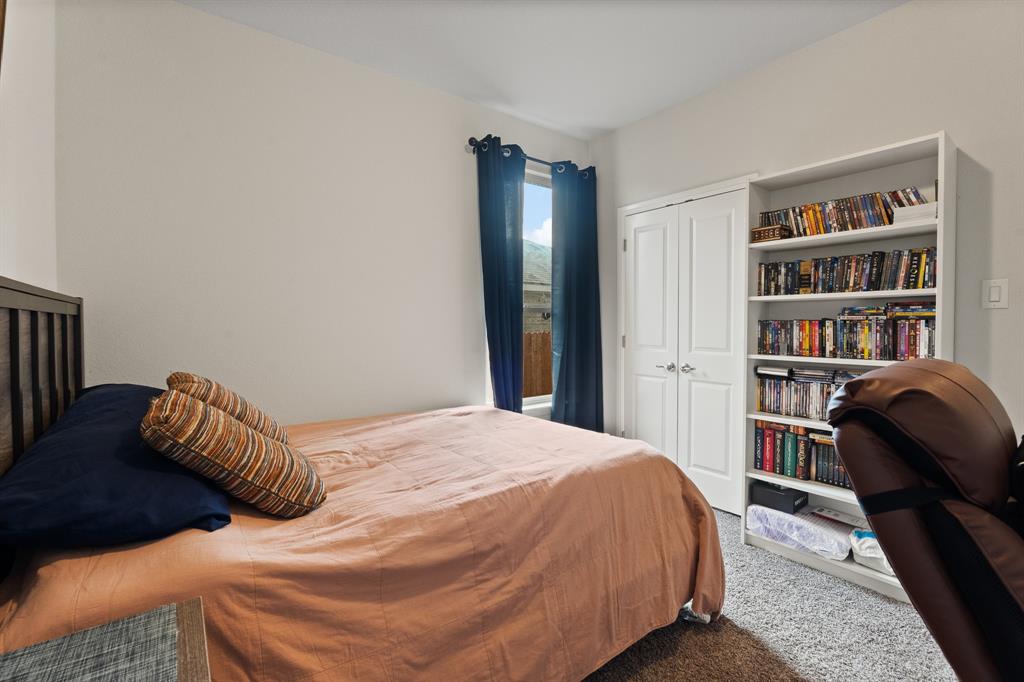 1812 Millbrae Road Cleburne, TX 76033 - Photo 21 of 30 Built-in shelving, white double-door closet, window with dark drapes, light neutral wall paint, and gray carpet