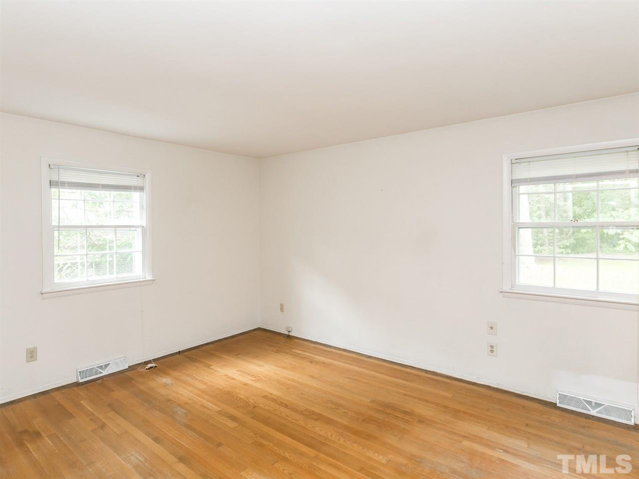 4813 Radcliff Road Raleigh, NC 27609 - Photo 8 of 22 an empty room with wooden floor and windows