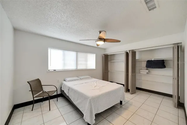 an empty room with wooden floor closet and windows