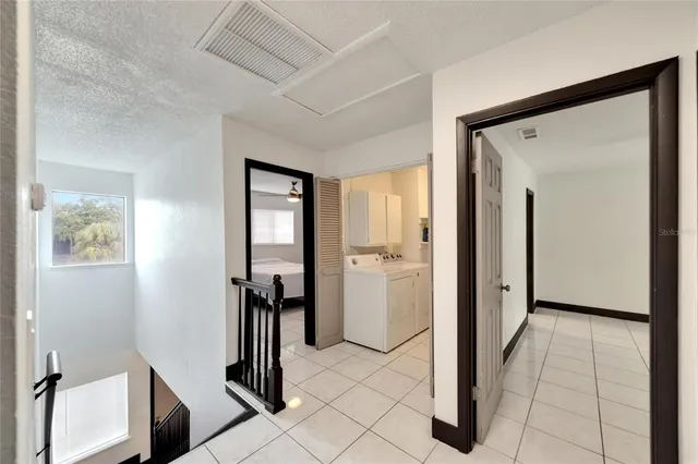 an empty room with wooden floor chandelier fan and windows