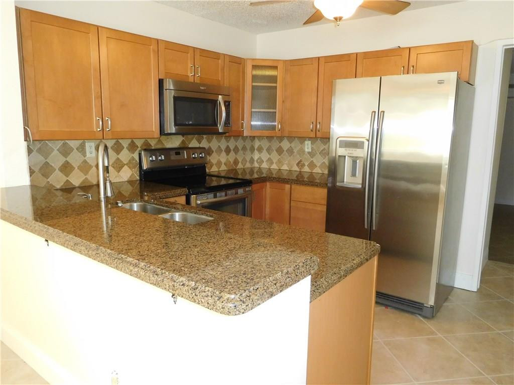 18897 Cloud Lake Circle Boca Raton, FL 33496 - Photo 4 of 23 a kitchen with kitchen island granite countertop a sink and a refrigerator