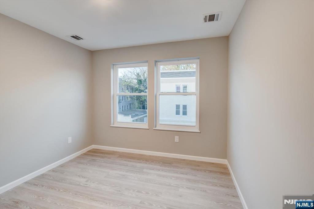 581 Bergen Street Newark, NJ 07108 - Photo 13 of 21 an empty room with wooden floor and windows