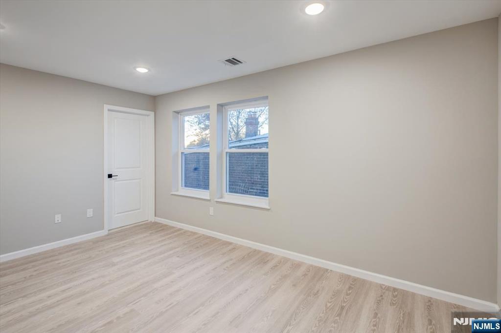 581 Bergen Street Newark, NJ 07108 - Photo 17 of 21 a view of an empty room with wooden floor and a window