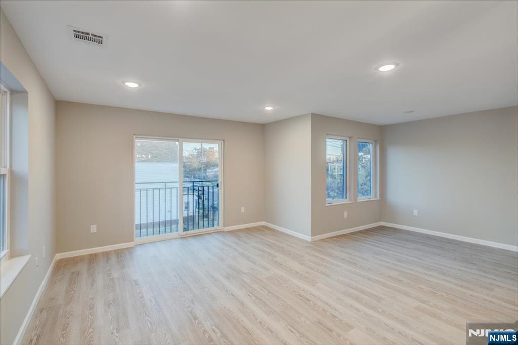 581 Bergen Street Newark, NJ 07108 - Photo 7 of 21 a view of an empty room with wooden floor and a window
