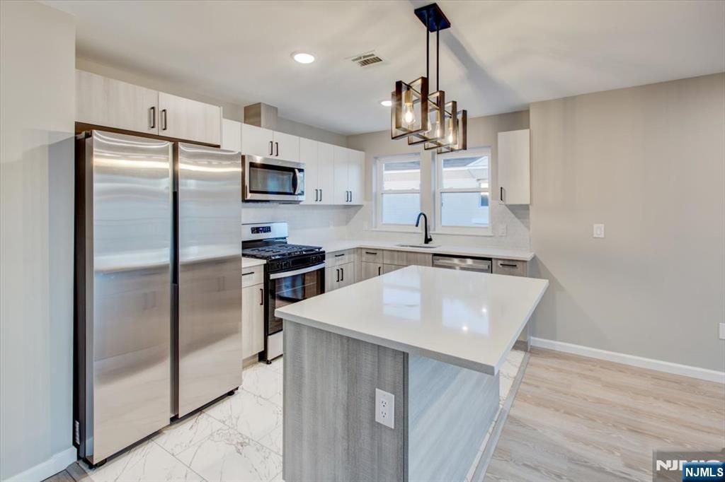 581 Bergen Street Newark, NJ 07108 - Photo 9 of 21 a kitchen with kitchen island a counter top space stainless steel appliances and cabinets