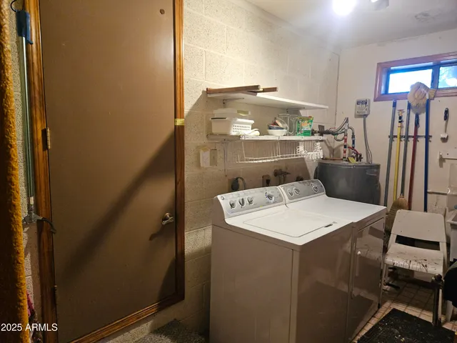 a room with water heater refrigerator washer and dryer