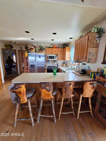 a dining area with stainless steel appliances a table and chairs