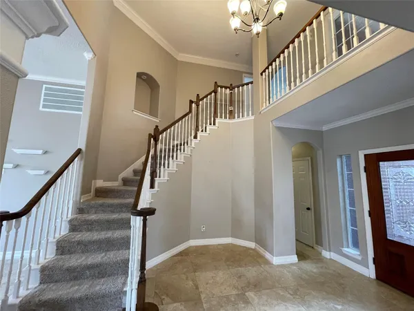 a view of staircase with lots of frames on wall and a window