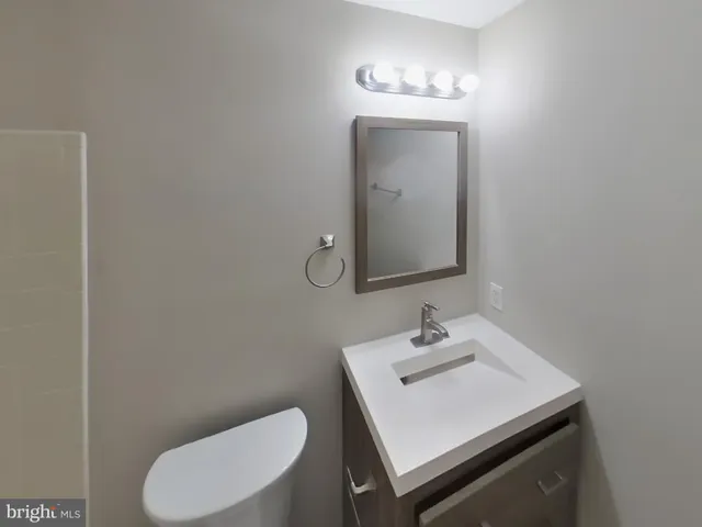 a bathroom with a toilet sink and mirror