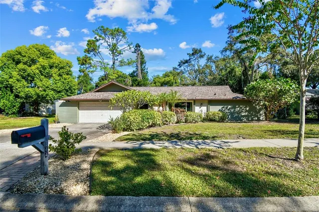 a view of a house with a big yard and large trees