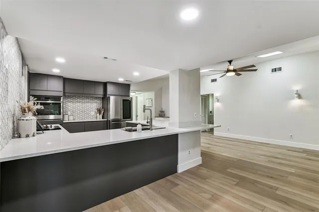 a view of entryway with kitchen view and wooden floor