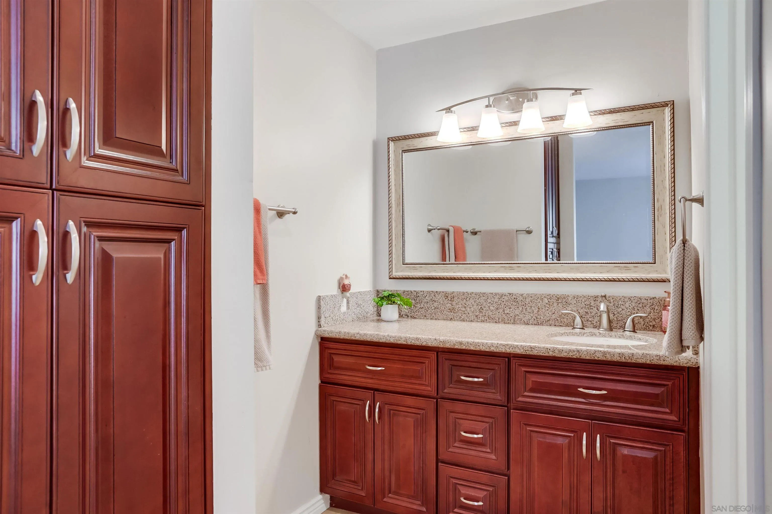 1775 Diamond Street, Unit 220 San Diego, CA 92109 - Photo 13 of 21 a bathroom with a granite countertop sink and a mirror
