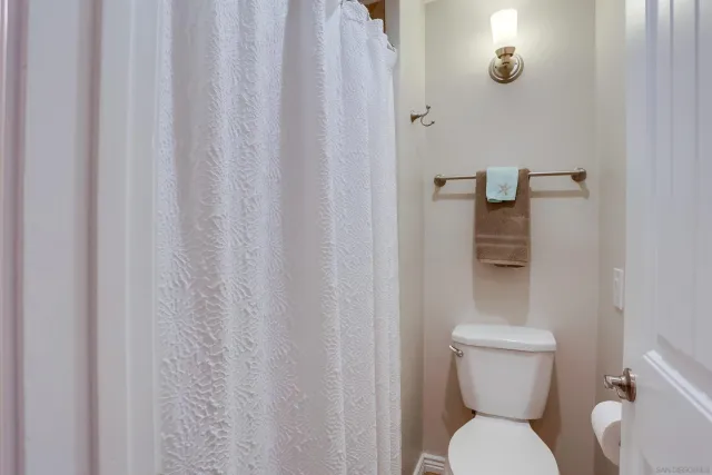 a white toilet sitting next to a shower curtain