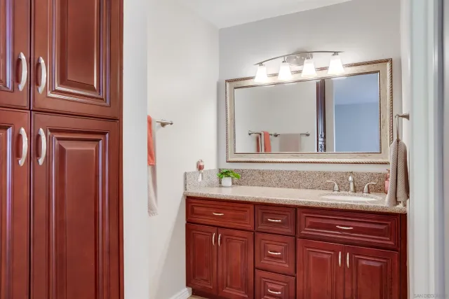a bathroom with a granite countertop sink and a mirror