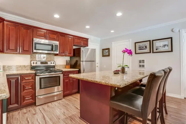a kitchen with stainless steel appliances granite countertop a stove refrigerator and a microwave