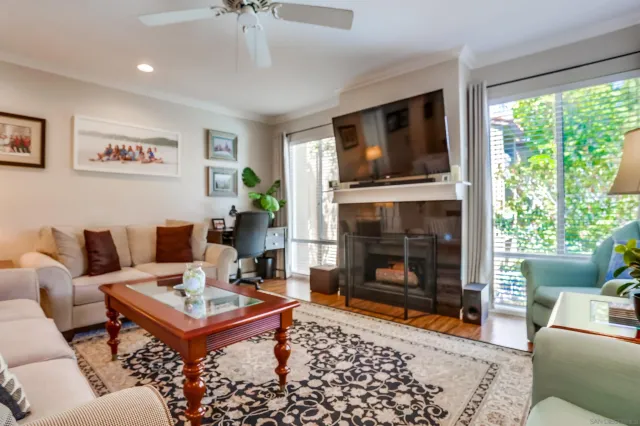 a living room with furniture a flat screen tv and a fireplace