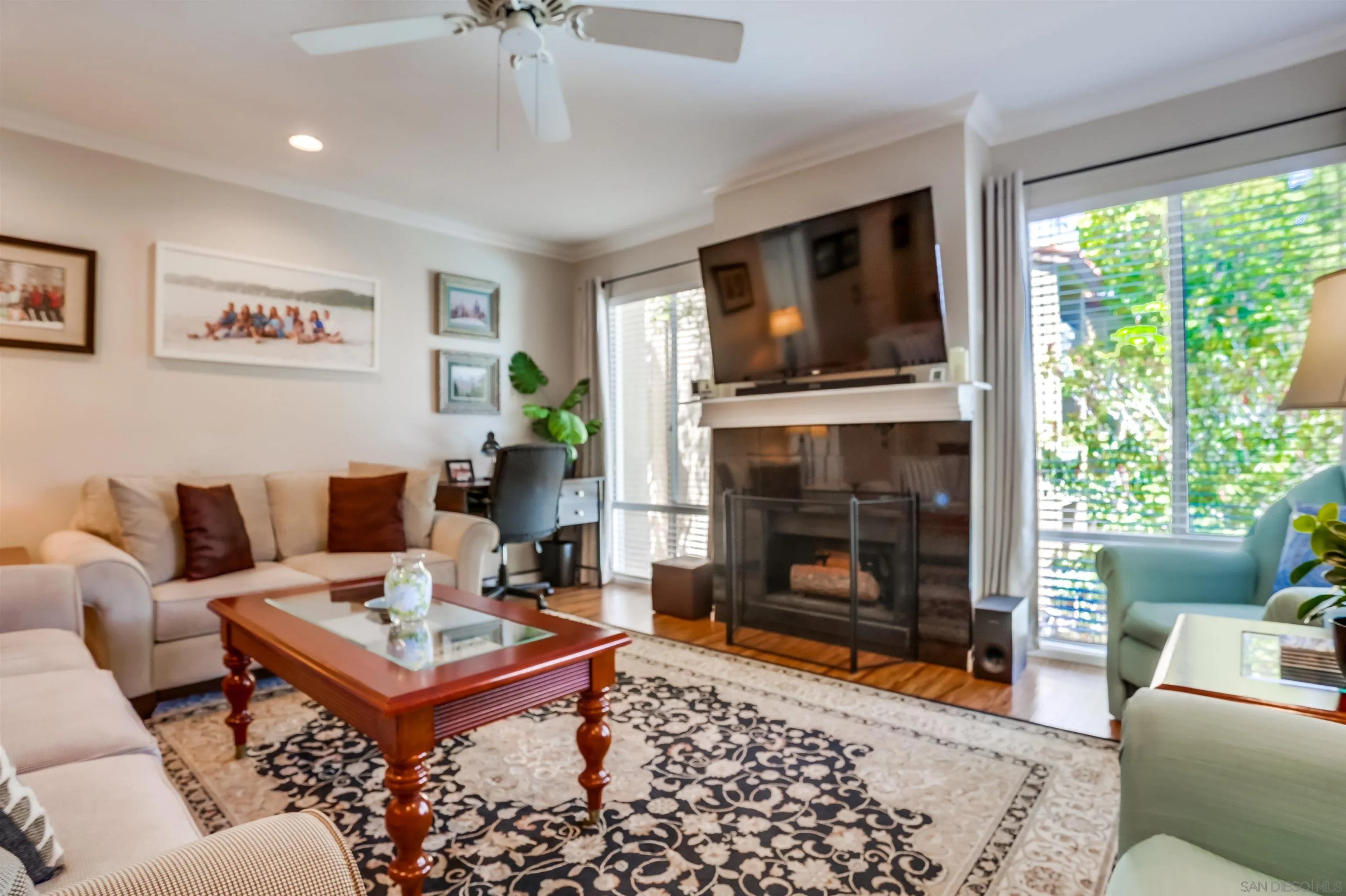 1775 Diamond Street, Unit 220 San Diego, CA 92109 - Photo 5 of 21 a living room with furniture a flat screen tv and a fireplace
