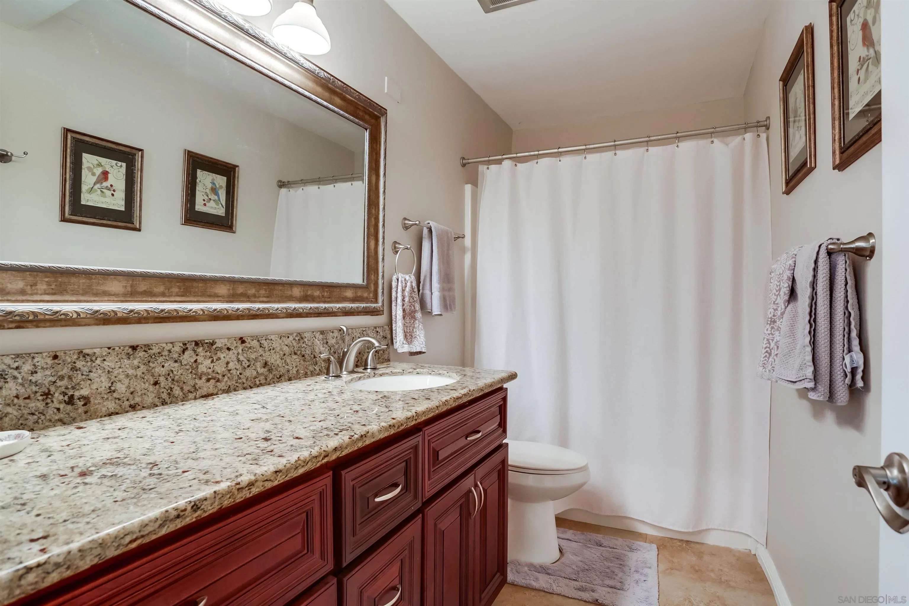 1775 Diamond Street, Unit 220 San Diego, CA 92109 - Photo 10 of 21 a bathroom with a granite countertop sink and a mirror