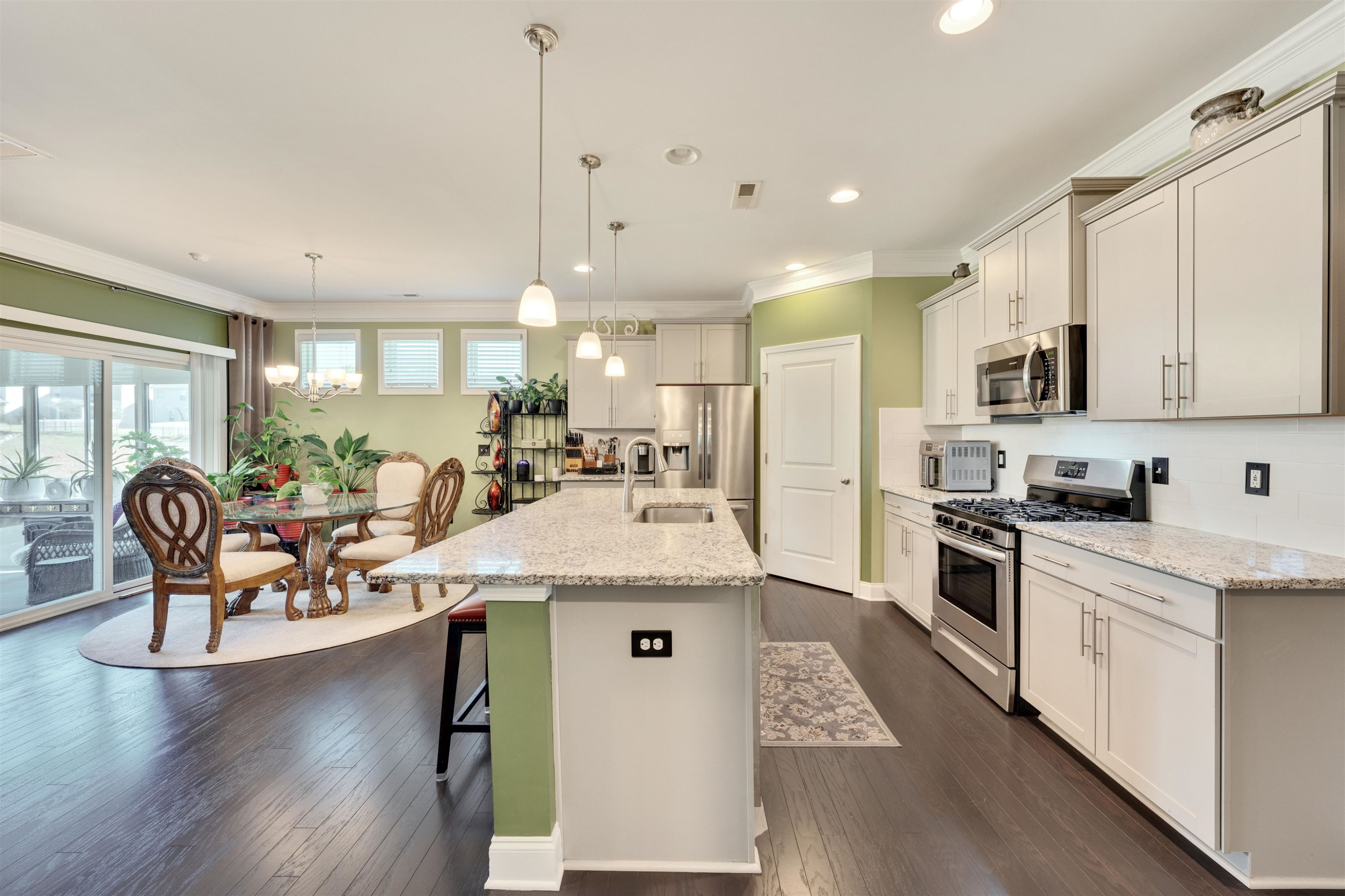 5317 Maplemoor Way Raleigh, NC 27616 - Photo 7 of 25 a kitchen with stainless steel appliances granite countertop a stove top oven a sink dishwasher a dining table and chairs with wooden floor