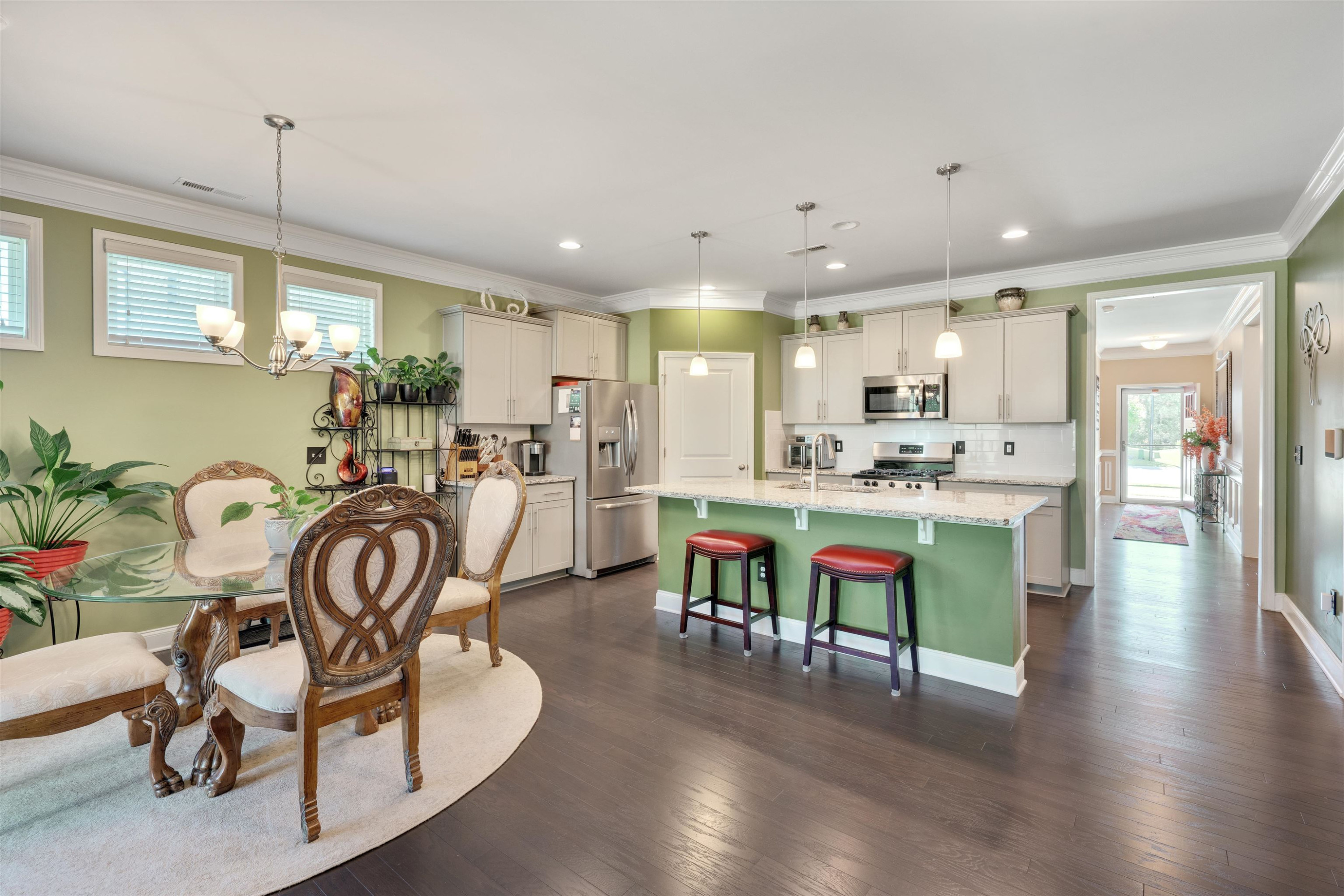 5317 Maplemoor Way Raleigh, NC 27616 - Photo 8 of 25 a kitchen with stainless steel appliances kitchen island granite countertop a dining table chairs refrigerator and sink