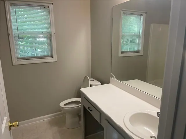 a bathroom with a sink a toilet and a window