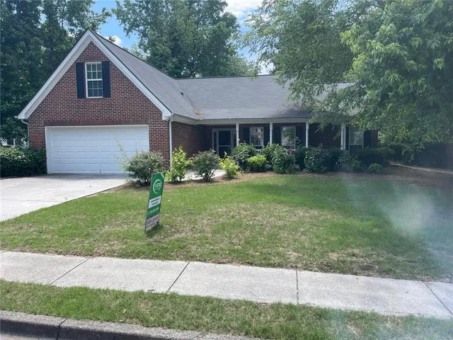 a front view of a house with a garden and yard