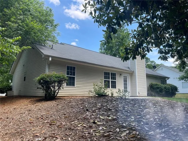 a view of a house with backyard and a garden