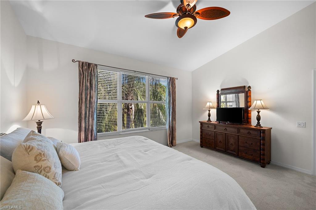 23785 Clear Spring Court, Unit 2305 Estero, FL 34135 - Photo 14 of 30 a bedroom with a bed and a chandelier