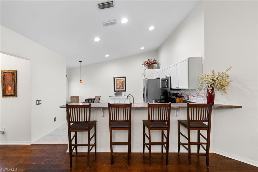23785 Clear Spring Court, Unit 2305 Estero, FL 34135 - Photo 10 of 30 a view of a dining room with furniture and wooden floor