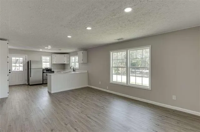 an empty room with a window and a fan