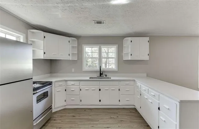 a kitchen with cabinets appliances a sink and a window