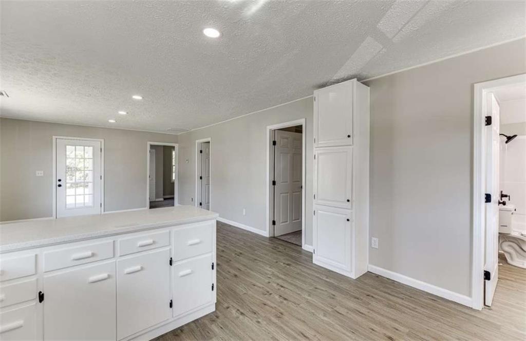 5554 Yonah Homer Road Alto, GA 30510 - Photo 5 of 25 a hall with white cabinets and wooden floor
