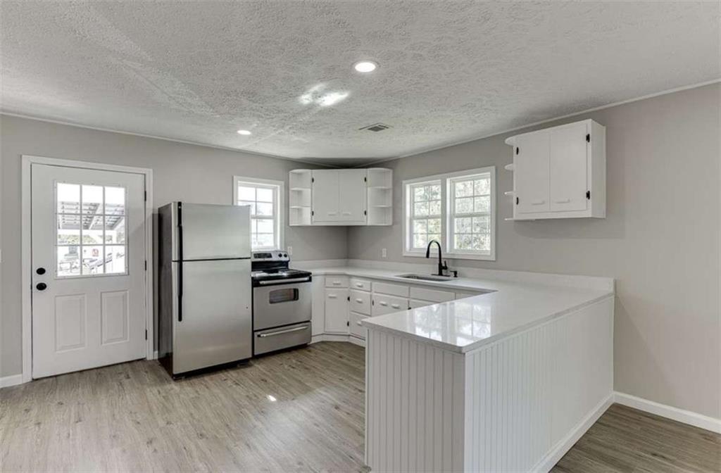 5554 Yonah Homer Road Alto, GA 30510 - Photo 6 of 25 a kitchen with a stove a sink and a refrigerator