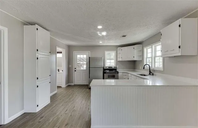 a kitchen with refrigerator a stove a sink and a stove