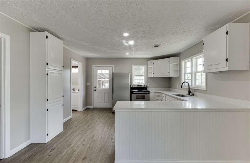 5554 Yonah Homer Road Alto, GA 30510 - Photo 7 of 25 a kitchen with stainless steel appliances a refrigerator sink and white cabinets