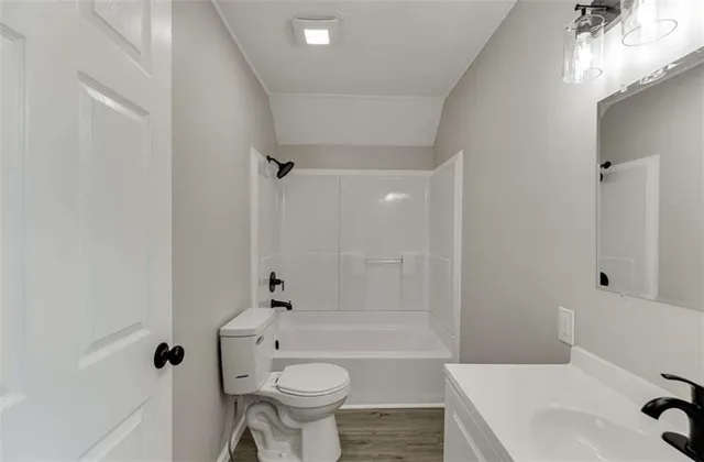 a view of a kitchen with wooden floor and a window