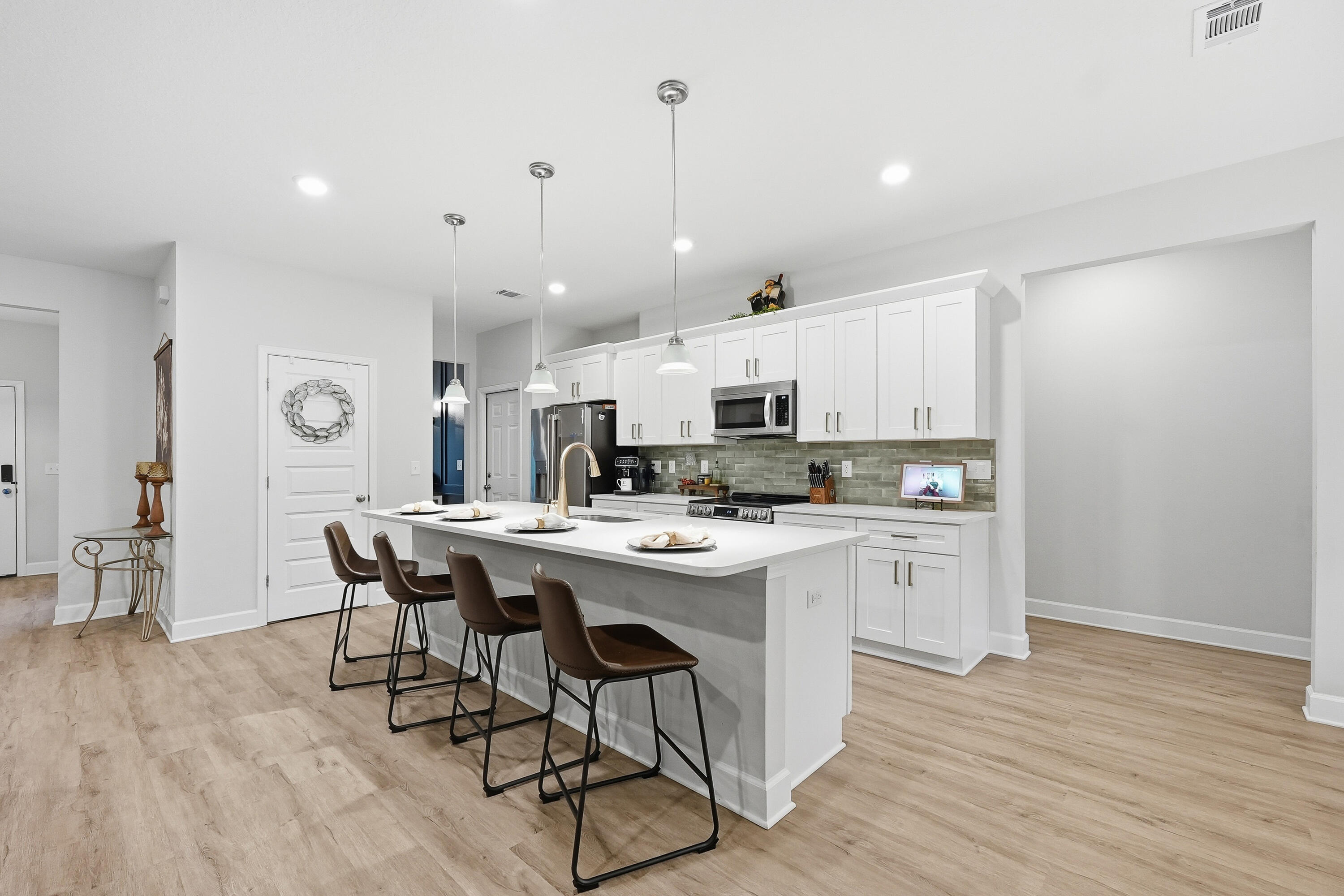 5833 La Porte Road Crestview, FL 32539 - Photo 15 of 44 a kitchen with stainless steel appliances a dining table chairs stove and white cabinets