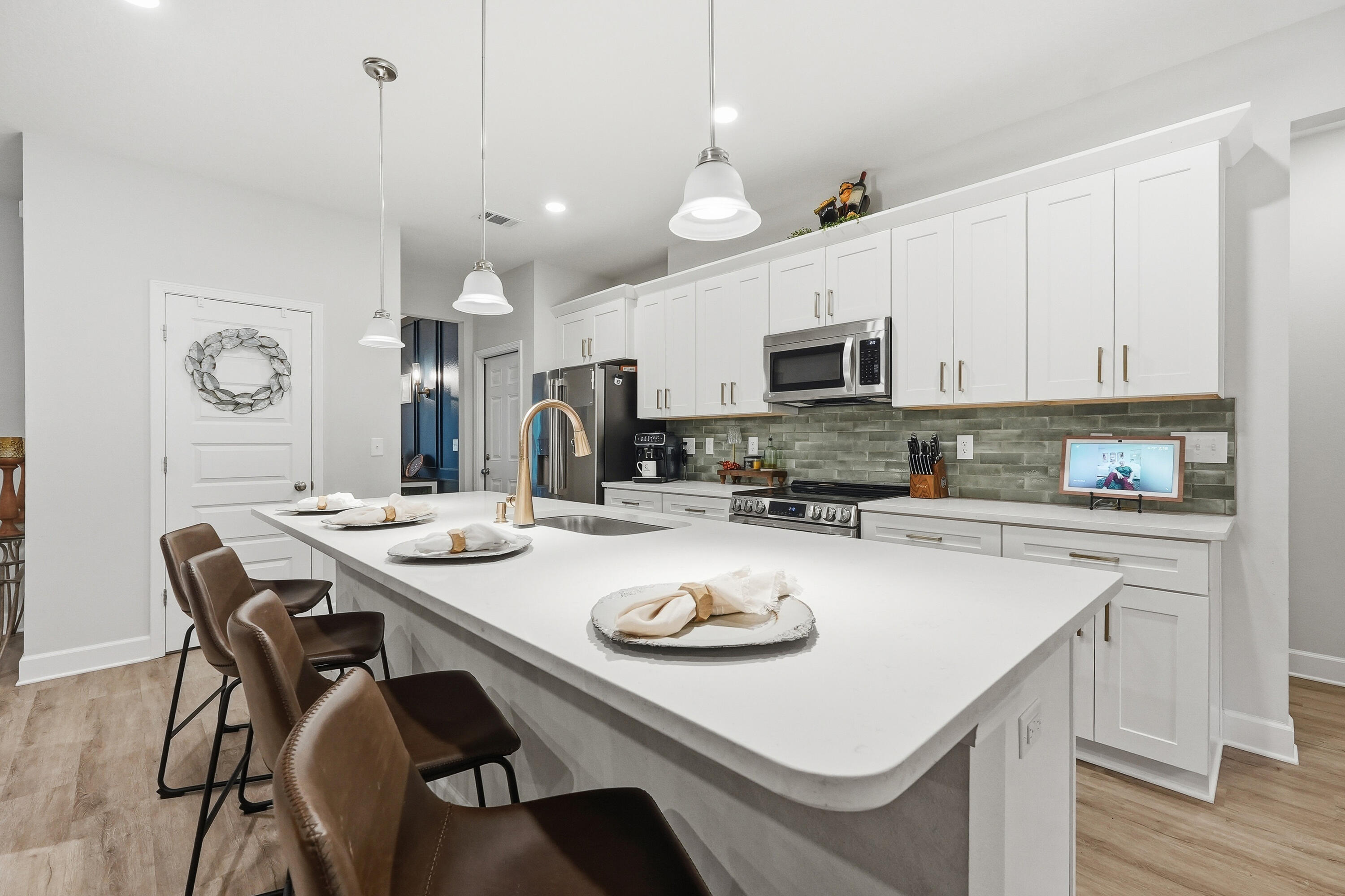 5833 La Porte Road Crestview, FL 32539 - Photo 16 of 44 a kitchen with a sink a stove a kitchen island with chairs and cabinets