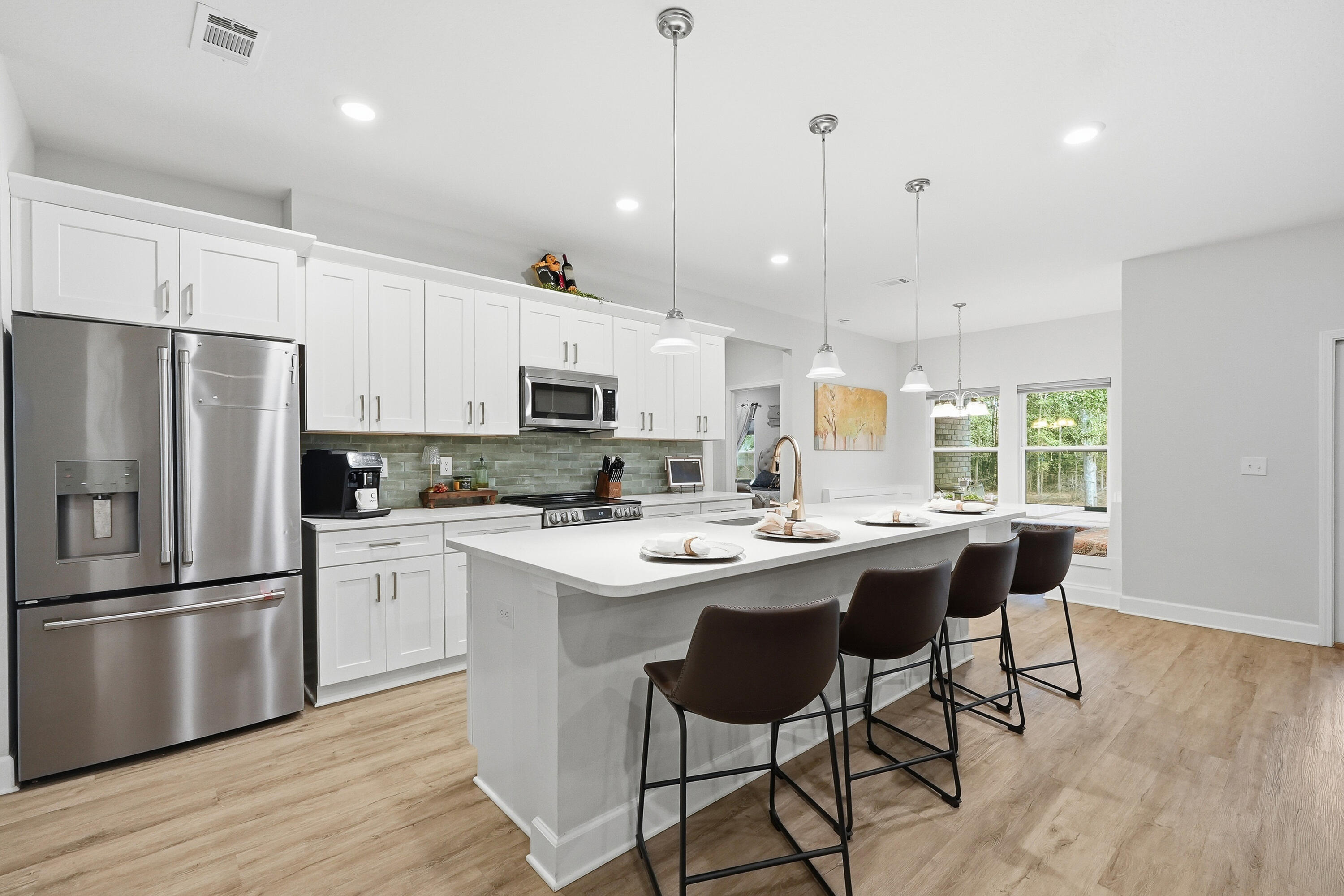 5833 La Porte Road Crestview, FL 32539 - Photo 17 of 44 a kitchen with stainless steel appliances kitchen island granite countertop a sink a stove a refrigerator and white cabinets with wooden floor