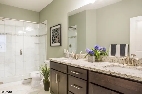 a bathroom with a granite countertop sink mirror and a toilet